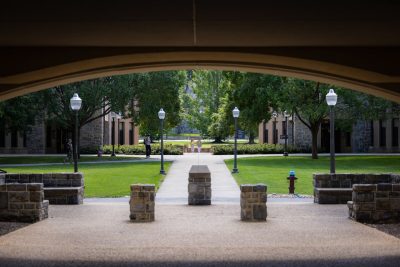 Four students walk outside the residence halls.